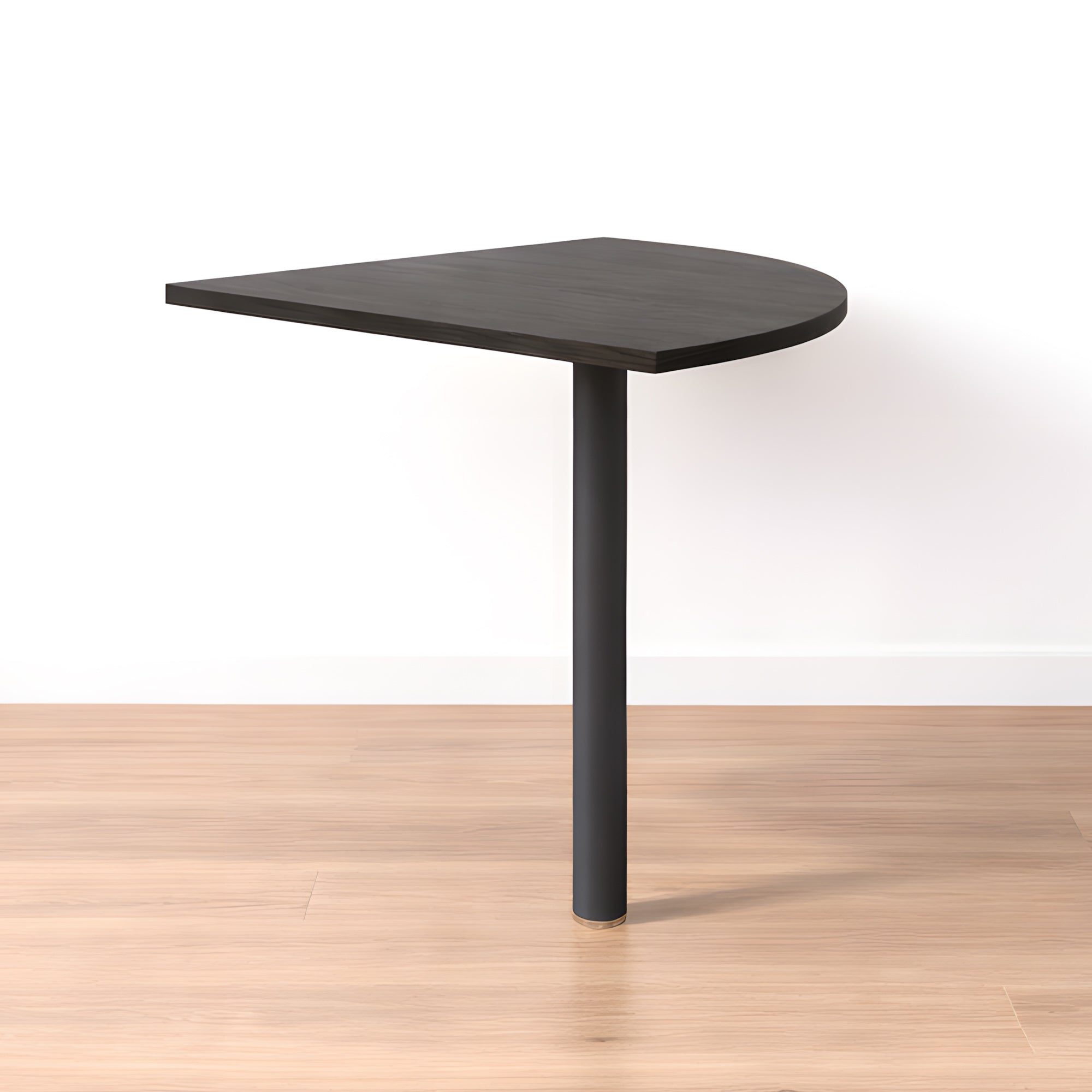 Le Bureau Pro Effect Droit ou Angle Modulable de Monsieur Bureau est un bureau compact en bois foncé avec des bords arrondis et un seul pied noir, reflétant le design italien, placé contre un mur blanc sur un sol en bois clair..#combo_frene_noir_anthracite_angle